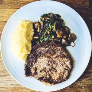 Bistec con puré de patatas y salteado de champiñones y chalotas